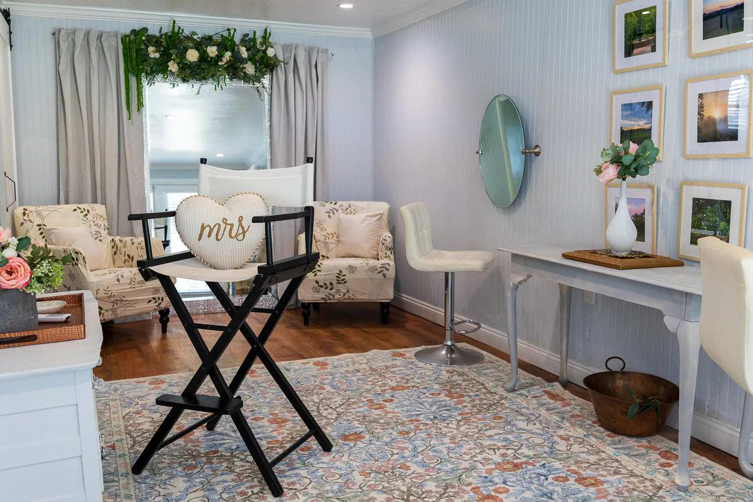 The Bridal Suite with a tall dressing chair, a flower-trimmed full-length mirror, and vanity seating.
