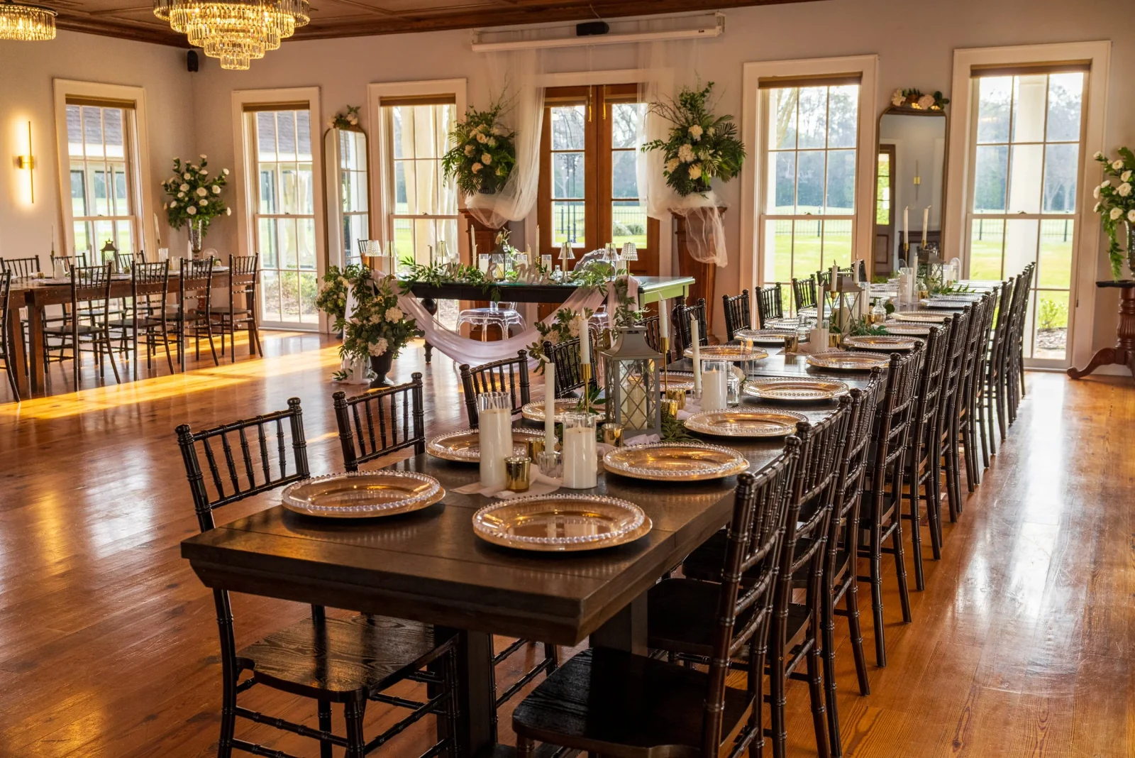 Dinner tables and chairs arranged beneath crystal chandeliers in the Oak Room.